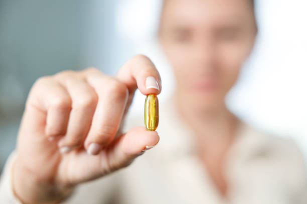istock Woman holding yellow soft gel capsule 1456826055