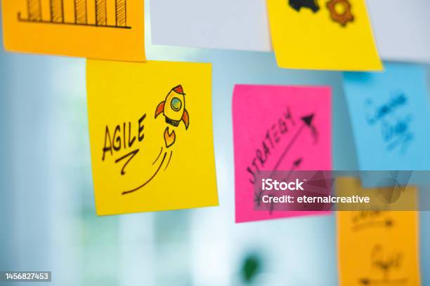 The Word Agile And Rocket Symbol On A Yellow Adhesive Note Stock Photo - Download Image Now