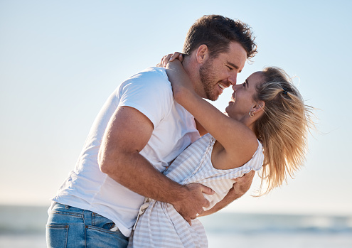 Couple, hug and love, happy at the beach with relationship and romance for bonding and together outdoor by the ocean. Romantic, care and travel date with man and woman hugging and quality time.