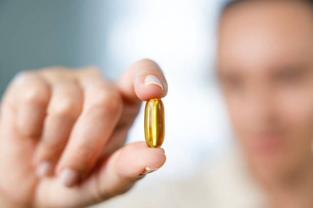 istock Woman holding yellow soft gel capsule 1456827653
