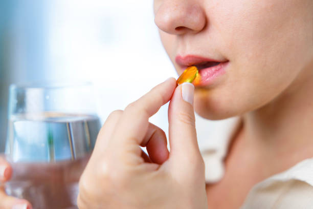 istock Young woman taking Omega 3 capsule 1456827716