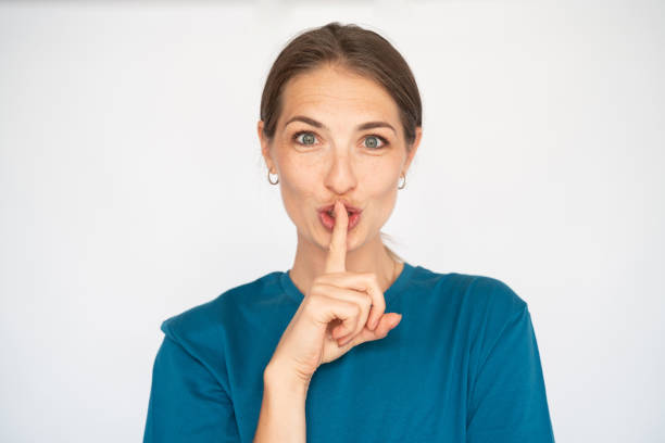 istock Cheerful Caucasian woman shushing 1456827961