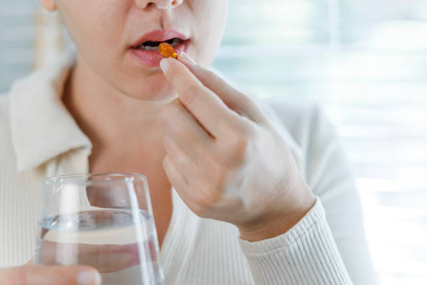 istock Young woman taking Omega 3 capsule 1456827988