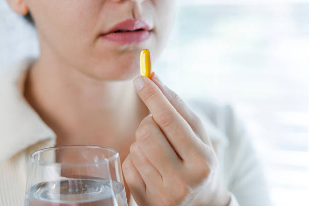 istock Young woman taking Omega 3 capsule 1456828011