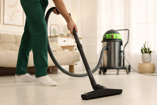istock Professional janitor vacuuming floor in living room, closeup 1456829449