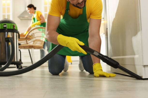 istock Professional janitor in uniform vacuuming floor indoors, closeup 1456829832