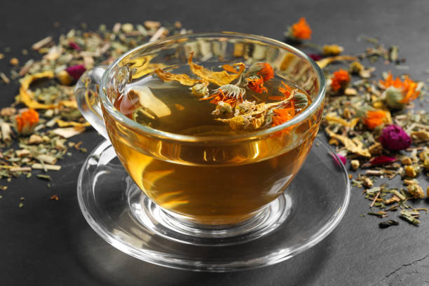 istock Freshly brewed tea and dried herbs on black table, closeup 1456831031
