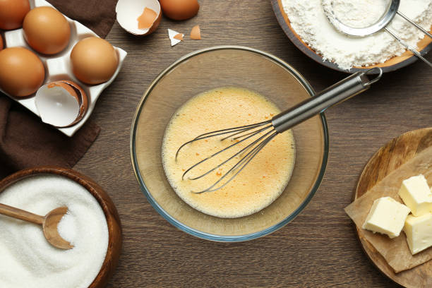 istock Beaten eggs, whisk and ingredients on wooden table, flat lay 1456831448