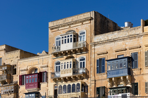 old medieval house facades and typical balconies in valletta city, malta island, europe.