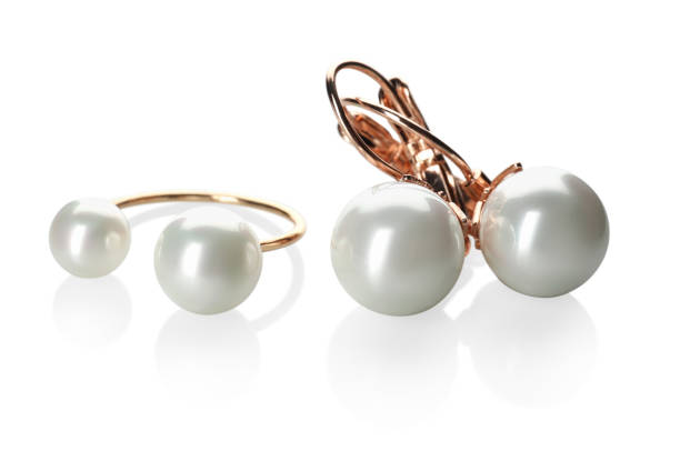 istock Elegant golden ring and earrings with pearls on white background 1456833184