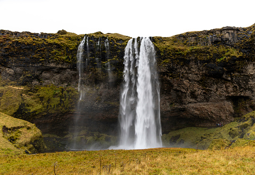 Seljalandsfoss is a waterfall in Iceland. Seljalandsfoss is a waterfall located in the South Region of Iceland right by Route 1. The waterfall drops 60 m (197 ft) and is part of the Seljalands River that has its origin in the volcano glacier Eyjafjallajökull. Visitors can walk behind the falls into a small cave.