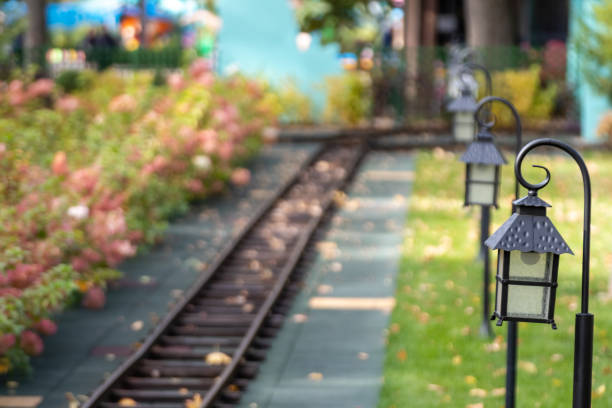 Outdoor entertainment railway attraction with lamp lanterns. Railway in summer amusement park with background blur
