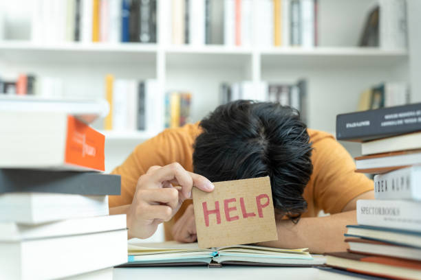 gli studenti asiatici hanno ansia a causa degli esami, il maschio si prepara per i test e le lezioni di apprendimento in biblioteca. stress, disperazione, fretta, incomprensione lettura, scoraggiamento, aspettativa, conoscenza, stanco - time pressure foto e immagini stock