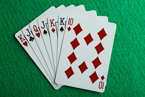 Playing cards on green table, top view
