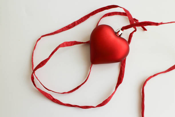 red heart with red ribbon on white background