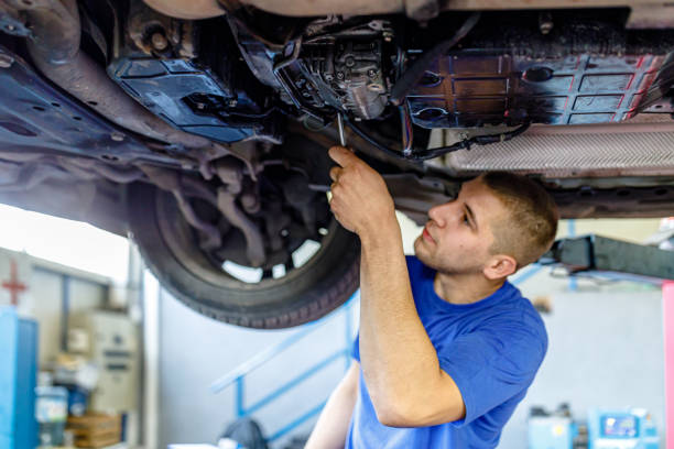 정비사가 정비사 장비를 사용하여 자동차 밑에서 작업하고 있습니다. - adjustable wrench expertise work tool maintenance engineer 뉴스 사진 이미지