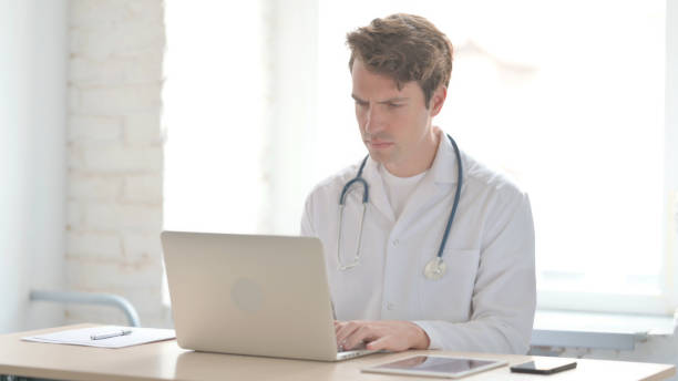 istock Young Doctor Working on Laptop in Clinic 1456846455
