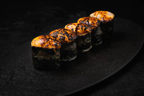 istock Sushi roll with baked sauce on top on black background 1456846740