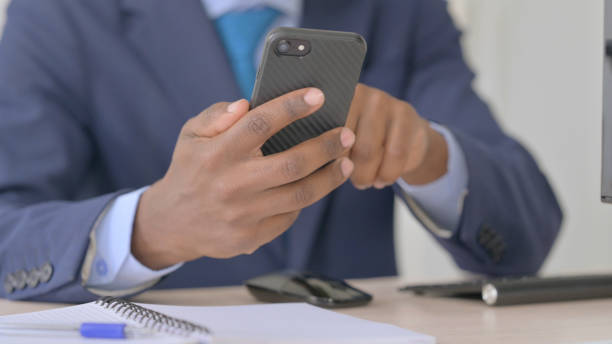 istock Young African Businessman Using Smartphone, Close Up 1456847495