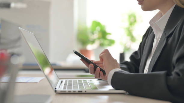istock Side View of Young Businesswoman Using Smartphone 1456849565