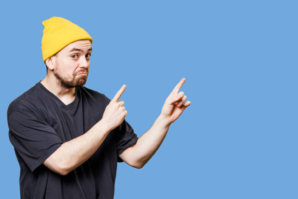 istock Bizarre Grimacing, Pointing to Free Space and Looking at Camera Handsome Bearded Guy Studio Portrait 1456849765