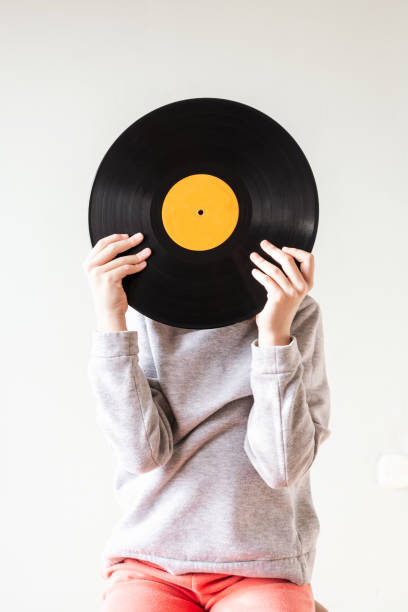 istock Child holding vinyl record in front of her face 1456851782