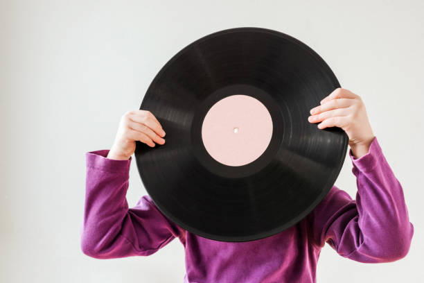 istock Child holding vinyl record in front of her face 1456851792