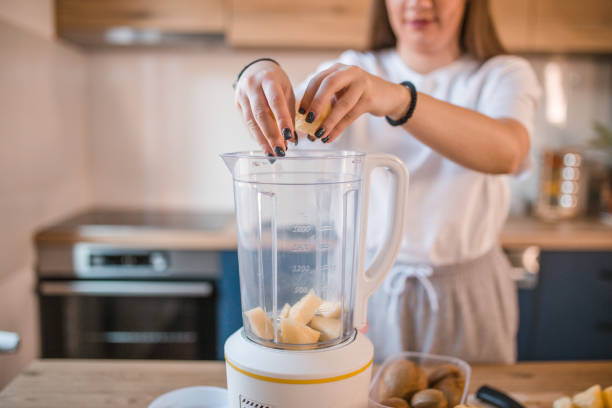 istock Unrecognizable athletic woman puts pineapple in blender 1456852183