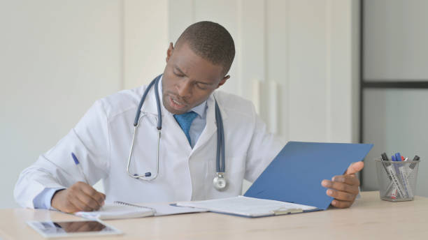 istock African Doctor Writing Medical Documents in Clinic, Paperwork 1456852313