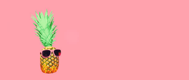 istock Funny pineapple with sunglasses looking away on pink background, blank copy space for advertising text 1456853242