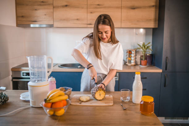 istock Smiling sporty woman cutting pineapple 1456853761