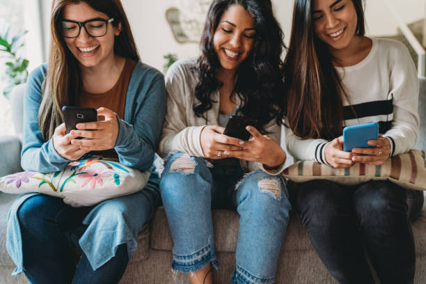 istock Three friends using mobile phones together at home 1456855028