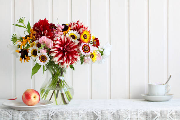 istock garden bouquet on a table with nectarine and a cup on a white wall, kitchen background. 1456856999
