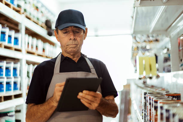 istock Elderly man working in a hardware store using digital tablet. Small business concept. 1456857609