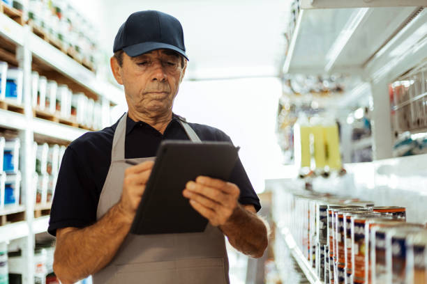 istock Elderly man working in a hardware store using digital tablet. Small business concept. 1456857641