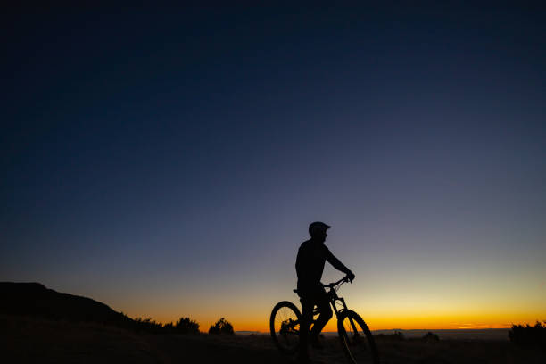 mountain bike silhouette dramatic sky stock photo