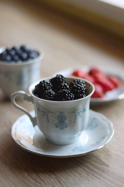 różne jagody w filiżankach vintage - berry fruit blueberry floral pattern strawberry zdjęcia i obrazy z banku zdjęć