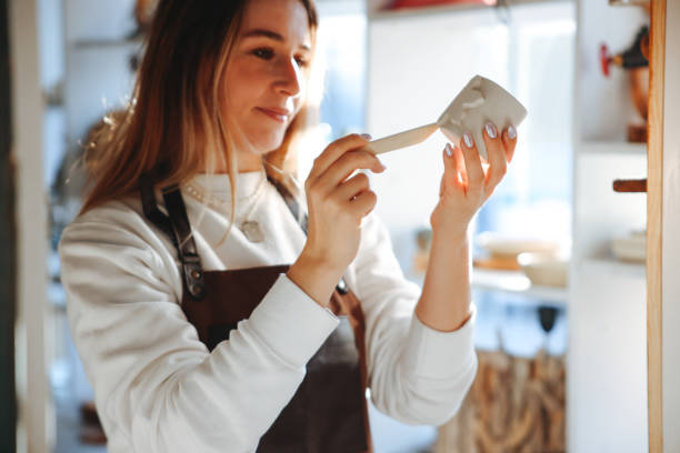 istock Smiling young woman wearing apron in cozy pottery studio 1456860324