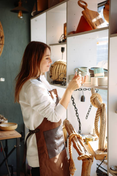 istock Smiling young woman wearing apron in cozy pottery studio 1456860756