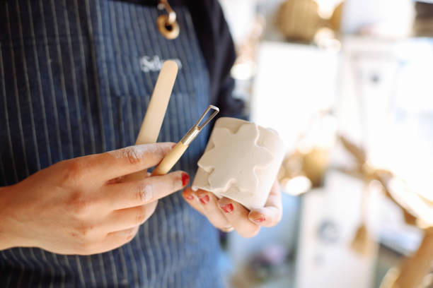 istock Smiling young woman wearing apron in cozy pottery studio 1456862178