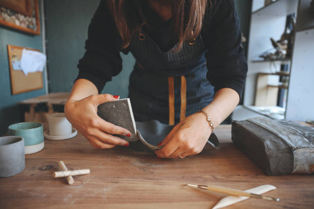 istock Smiling young woman wearing apron in cozy pottery studio 1456864137