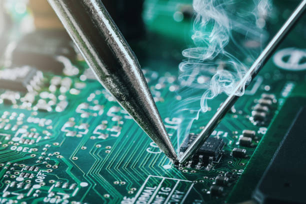 istock soldering iron solder the computer chip on circuit board. closeup 1456865129