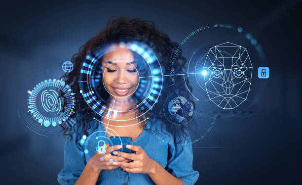 African American businesswoman typing on smartphone with facial recognition stock photo