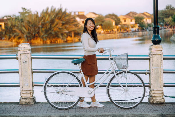 istock vietnamese woman crossing bridge with bicycle 1456868593