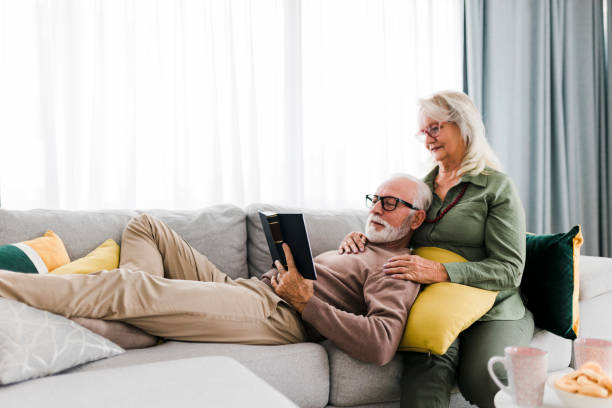 istock Senior couple reading book and resting at home 1456869855