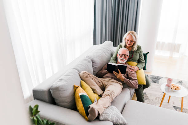 istock Senior couple reading book and resting at home 1456869960