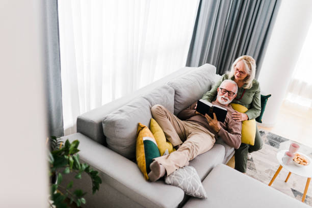 istock Senior couple reading book and resting at home 1456870006