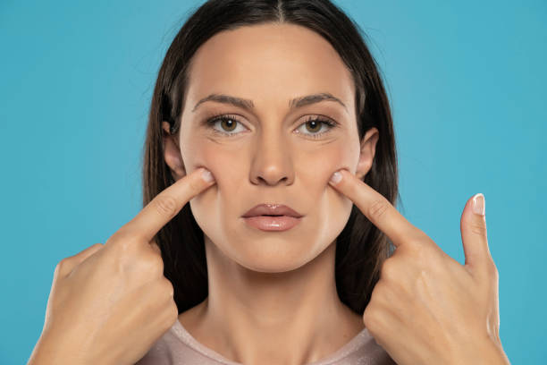 istock young woman touches her cheeks on a beige background 1456870193