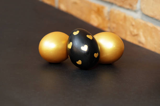 istock Gold, black and white Easter eggs on a dark gray background. 1456871228