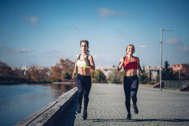 istock Two beautiful women perform outdoor exercise in park. 1456872614